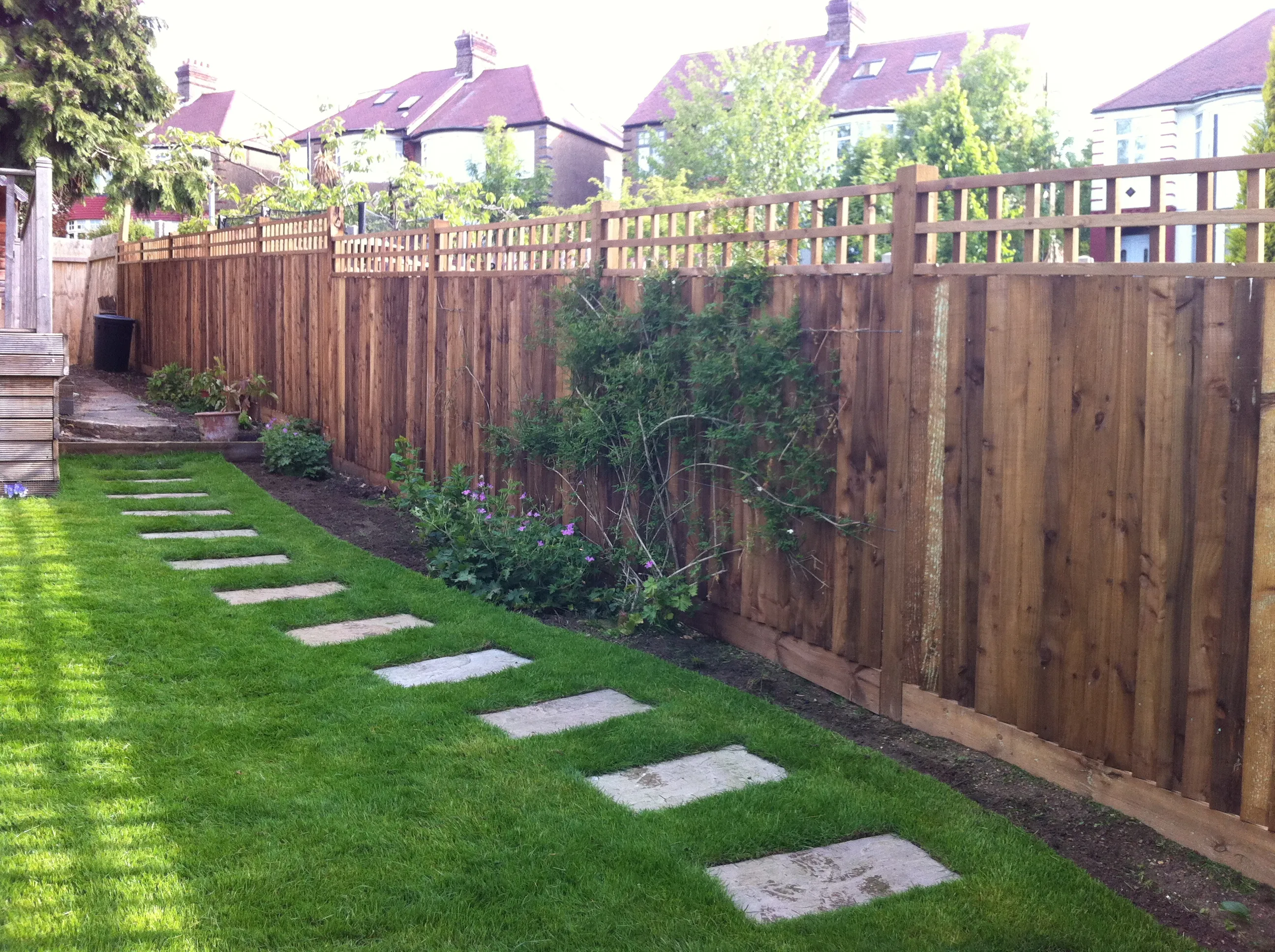 Timber fencing alongside a stepping-stone path and lawn in a North London garden